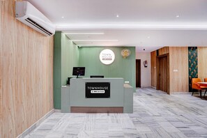 A reception desk with a sign indicating it's serviced by OYO.