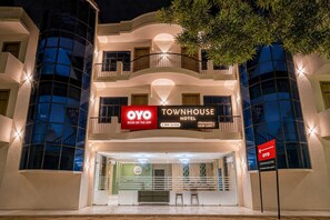 A multi-story building with a sign for 'OYO Townhouse Hotel' and a 'BOOK ON THE APP' prompt.
