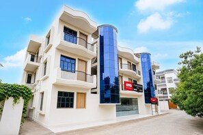 A multi-story building with balconies, a storefront, and a sign for 'OYO TOURNHOUSE'.