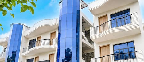 A multi-story hotel with balconies, a prominent blue glass facade, and a sign for the 'Townhouse Hotel'.