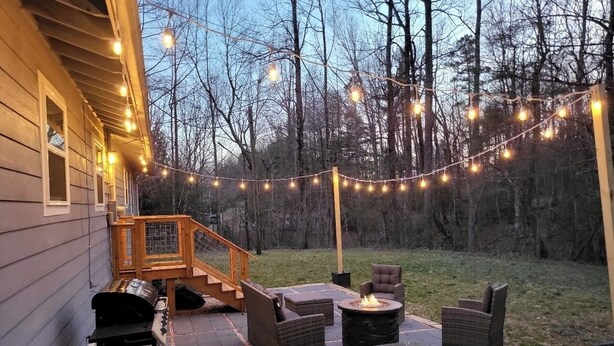 A patio with outdoor furniture, a grill, and string lights. - A 3-bedroom mountain retreat perfect for families, friends, and every adventure! (Zirconia)