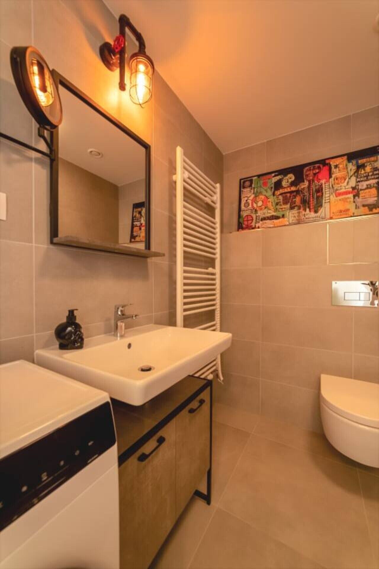 Un bagno con lavandino, specchio, portasci e servizi igienici.