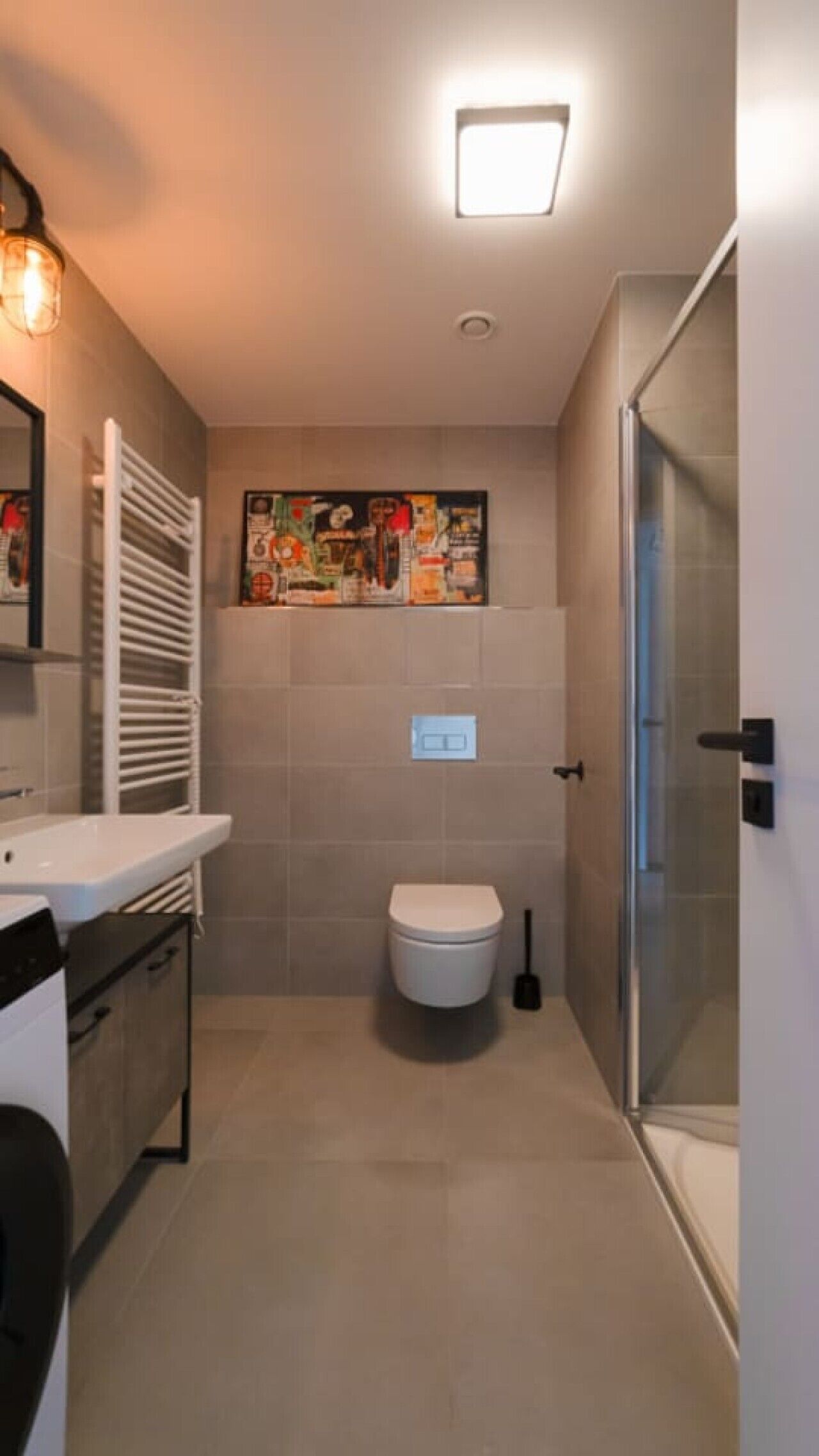 A bathroom with a toilet, a shower, a sink, and a mirror.