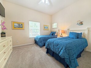 A bedroom with two beds, a dresser, a ceiling fan, and two windows. - Bright resort condo with private balcony - Bahama Bay (Davenport)