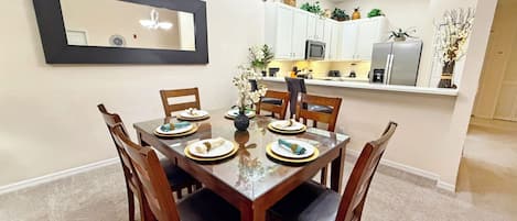A dining area with a rectangular table, six chairs, and a large mirror on the wall.