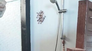 A shower area with a wooden floor, a showerhead, and a wooden post. - Fare Miki Miki (Huahine)