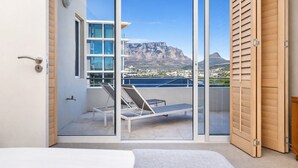 Ein Schlafzimmer mit Balkon, einem Bett und Blick auf einen Berg.