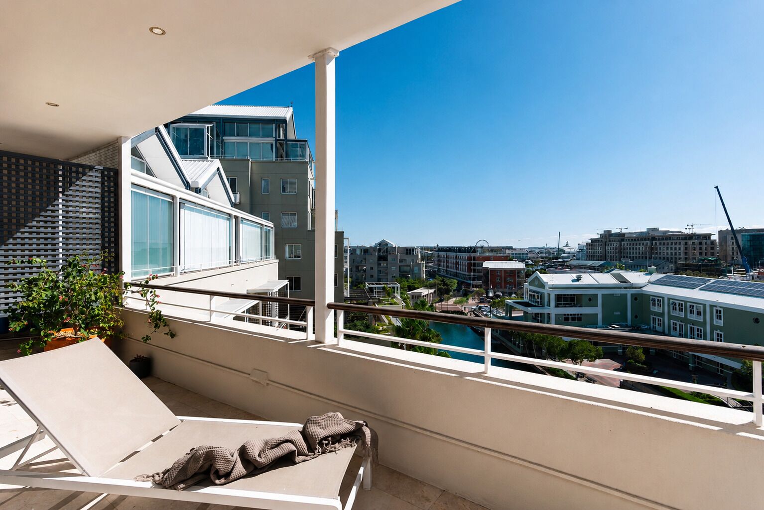 Un balcon offrant une vue sur le paysage urbain, avec notamment une grande roue et des bâtiments modernes.