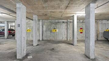 Een parkeergarage met betonnen pilaren en genummerde parkeerplaatsen.