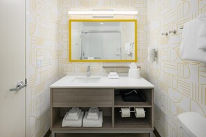 A modern bathroom with a white sink, mirror, and toilet. There are towels and toiletries on the sink and toilet. - Home2 Suites By Hilton Chattanooga West Lookout Mountain (Chattanooga)