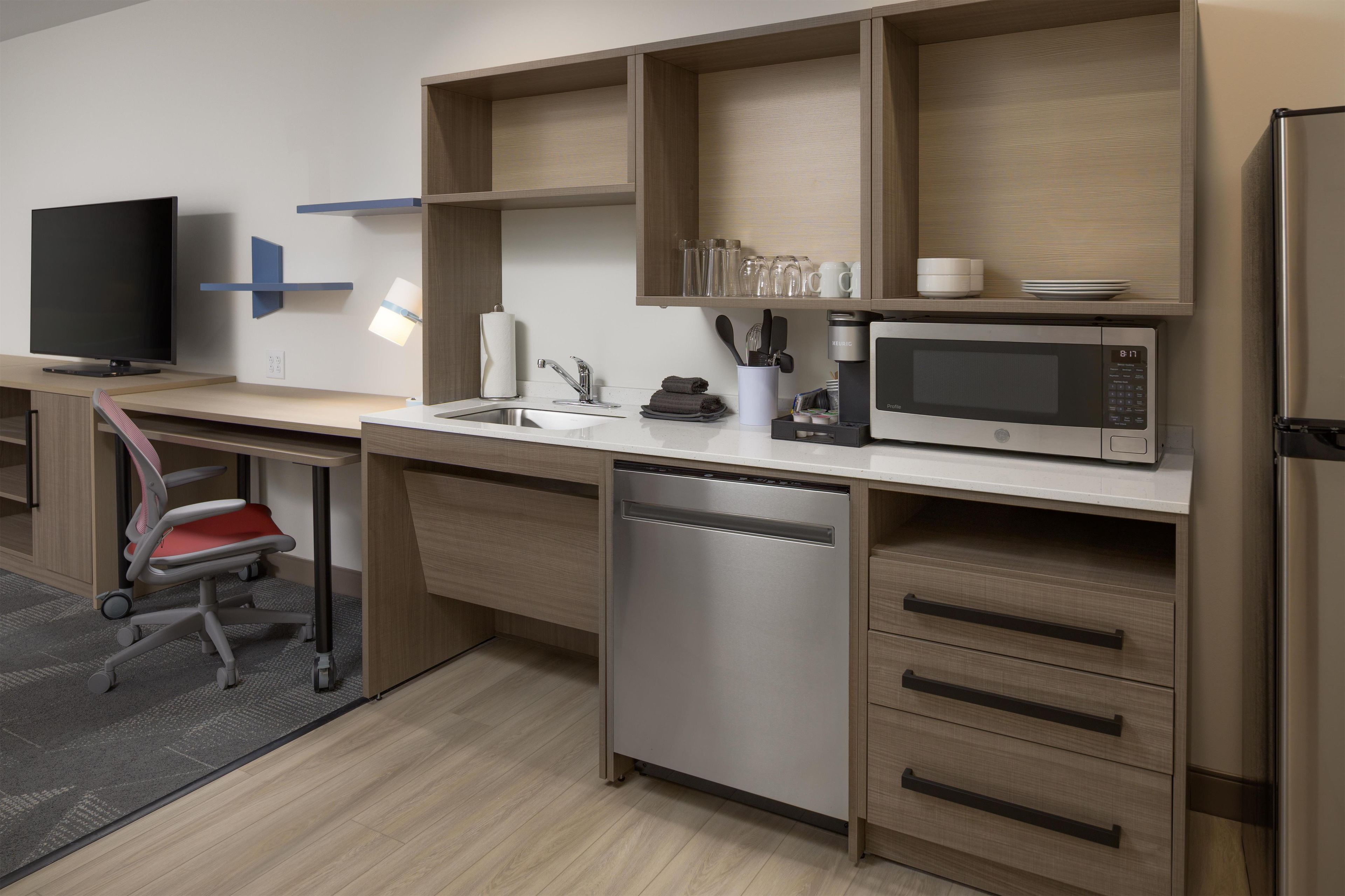A modern kitchen with a built-in dishwasher, a microwave, and a coffee maker.