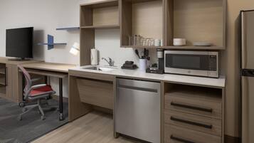 A modern kitchen with a built-in dishwasher, a microwave, and a coffee maker.