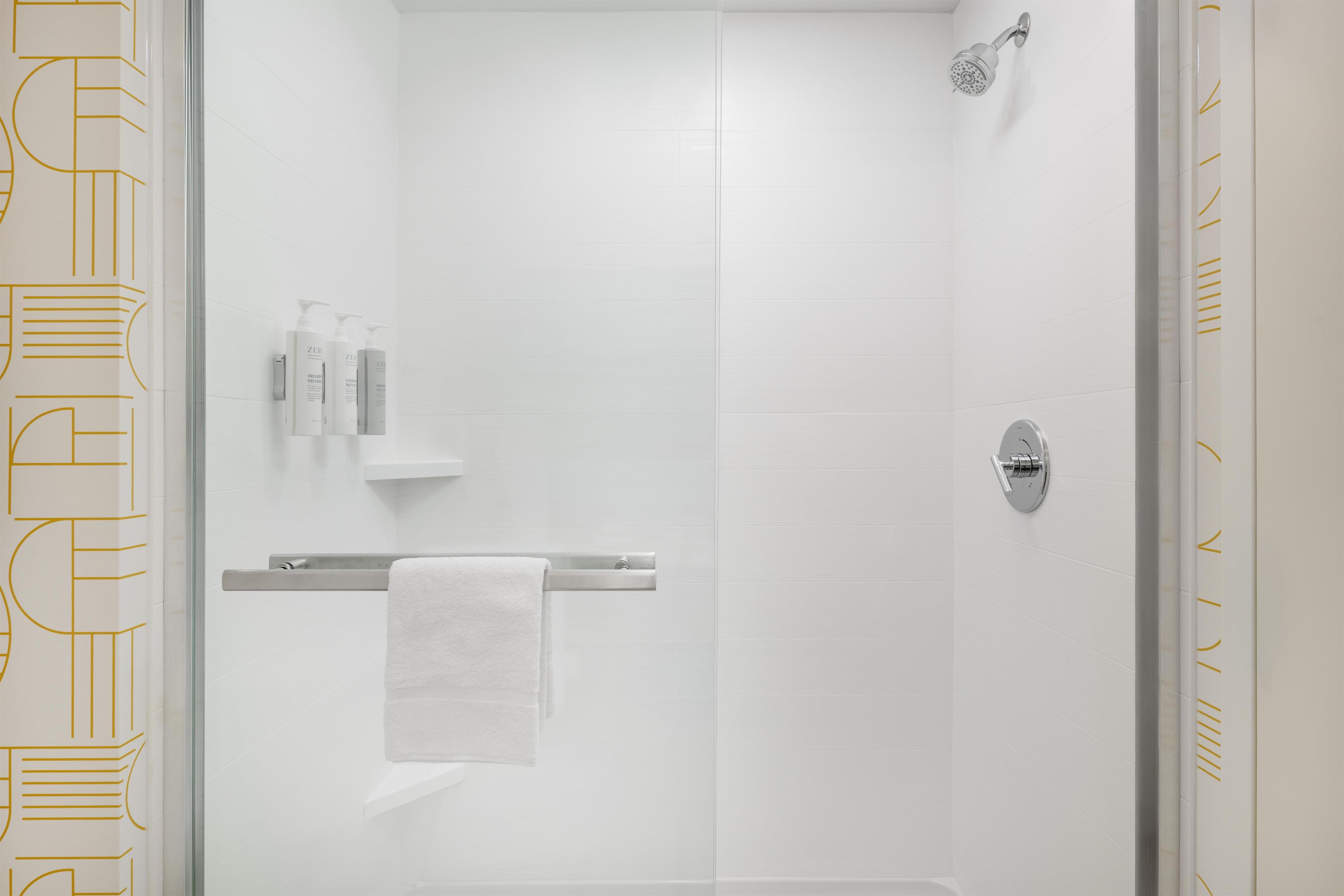 A modern bathroom with a glass shower enclosure, a towel rack, and a toilet.