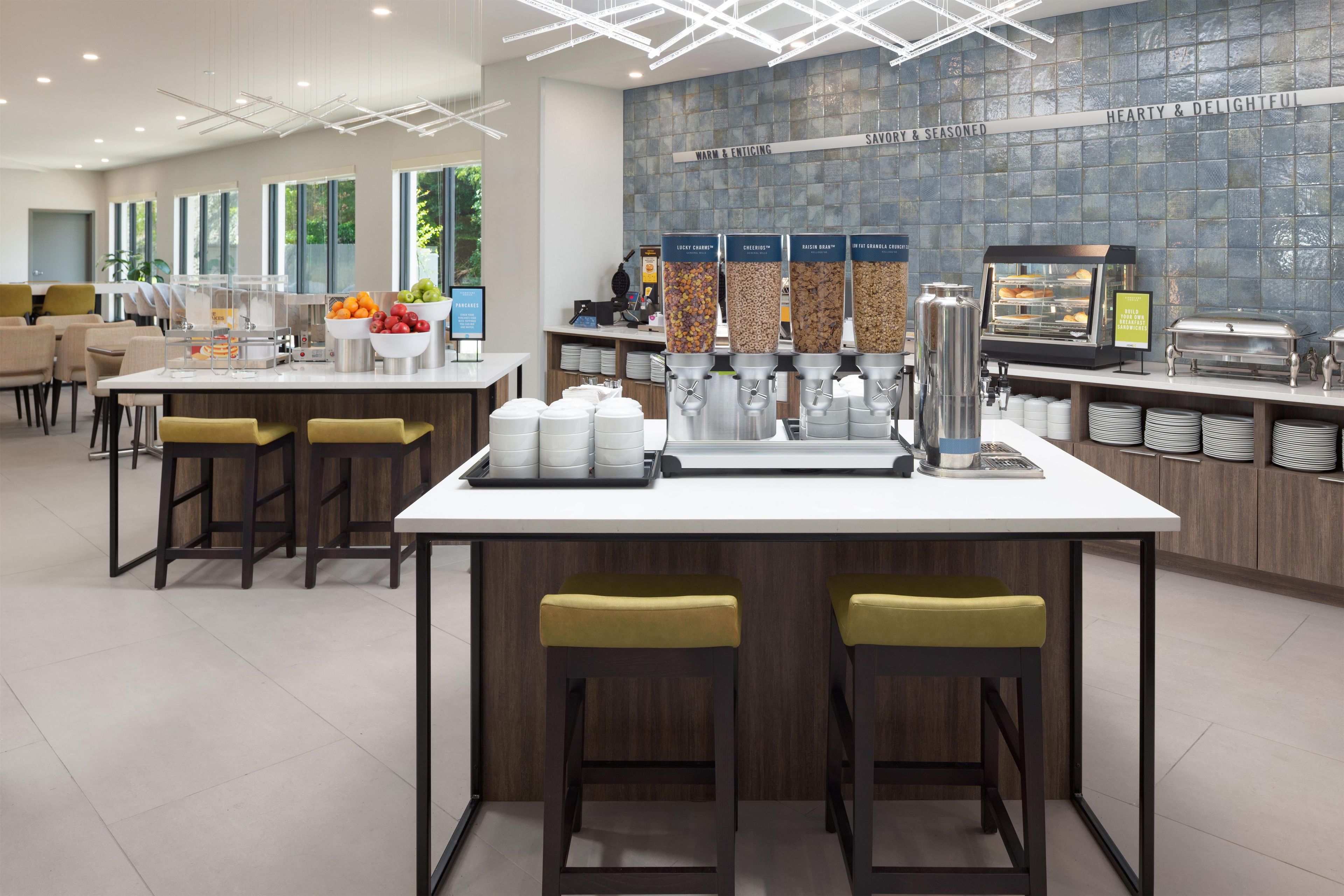A modern breakfast bar with a coffee machine, cereal dispensers, and a fruit bowl.