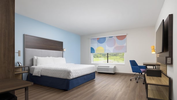A modern hotel room with a bed, desk, chair, and a large window with a view. - Tru By Hilton Chattanooga West Lookout Mountain (Chattanooga)