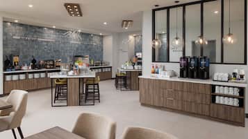 A modern kitchen with a central island, bar stools, and a breakfast bar.