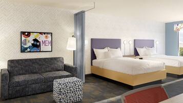 Ein Hotelzimmer mit einer Wannenmuster-Wand, einem gerahmten Bild, einem Sofa, einem Bett, einem Nachttisch und einem gemusterten Ottoman.