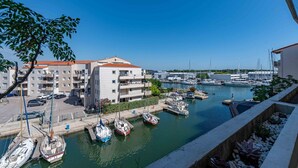 A marina with boats docked, a building with balconies, and a clear blue sky. - Marine de port, boats and relaxation (Canet-en-Roussillon)