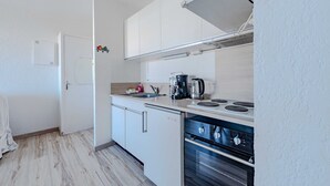 A compact kitchen with a stove, oven, and a small countertop area. - Marine de port, boats and relaxation (Canet-en-Roussillon)