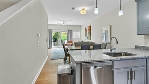 Eine moderne Küche mit Geschirrspüler, Granit Arbeitsplatte und Pendelleuchten.