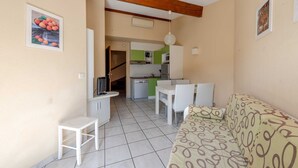 A compact living space with a kitchenette, a dining area, and a sofa. - Les jardins de Neptune, pool and relaxation (Saint-Cyprien)