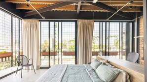 Een moderne slaapkamer met een groot bed, een bureau en een stoel.