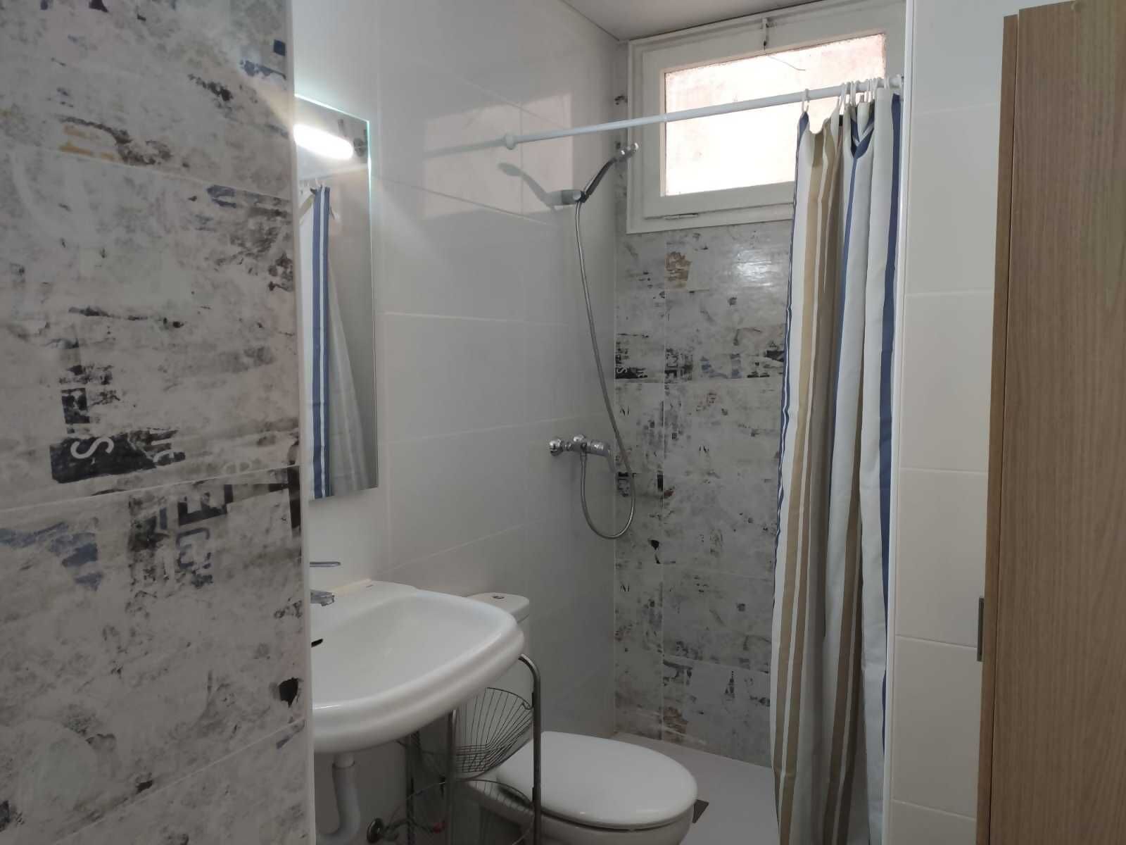 Un baño con ducha, lavamanos e inodoro.