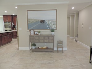 A kitchen with wooden cabinets, a built-in oven, and a dining area with a bench and a small table. - Clovis Foothill Retreat, Spa, BBQ & Mountain Views (Clovis)