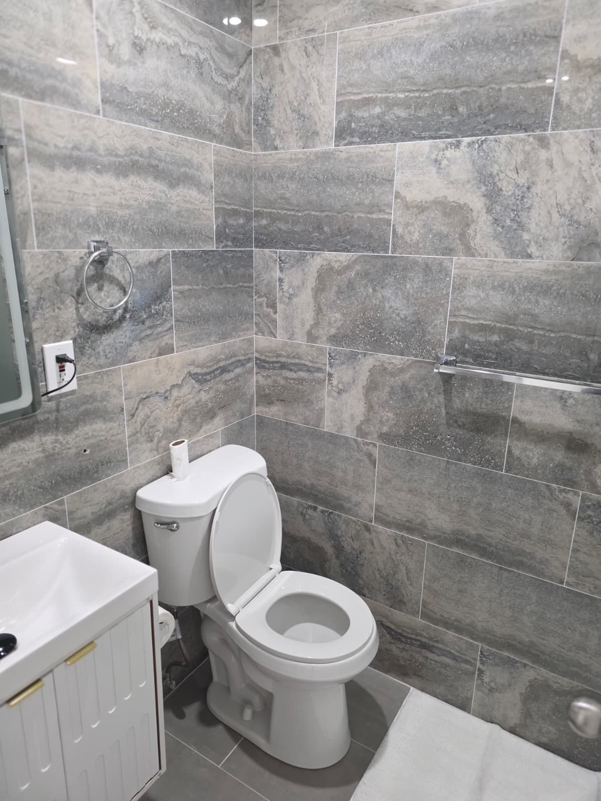 A bathroom with a toilet, sink, and shower area.