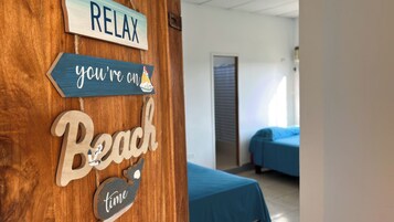 A wooden wall with signs reading 'RELAX,' 'you're on the beach,' and 'time.'