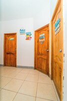Un pasillo con puertas de madera, cada una decorada con un letrero alusivo a una playa.