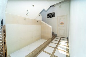 A staircase with beige tiles leading to a door with a circular emblem.