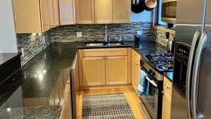 A modern kitchen with wooden cabinets, a granite countertop, a stainless steel refrigerator, and a gas stove. -  3bd-2ba stand alone condo with POOL and no hwy noise 5 min- Vail Village (Vail)