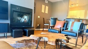 A modern living room with a flat-screen TV, leather sofas, a coffee table, and a unique wooden rug. - Home-like 3-bedroom condo with Resort Amenities in beautiful Phoenix (Phoenix)