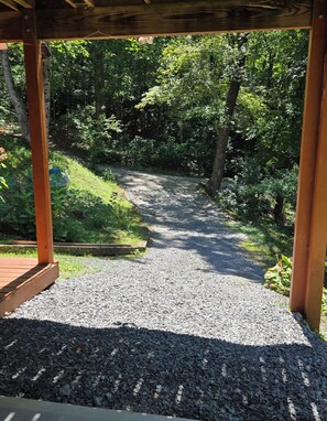 A gravel pathway leading into a wooded area, framed by wooden structures. - Hideaway Hollow Cabin, Mtn view, Bed swing, hot tub near Ocoee River/Copperhi... (Murphy)