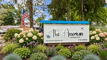 Une enseigne pour l’hôtel The American Boutique Hotel, avec l’adresse de son site web et son adresse postale.