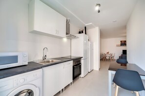 A modern kitchen with a microwave, oven, and sink. - LXR Navegante 2-Bedroom Next to the Sea (Fuengirola)