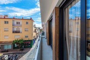 A narrow urban street with buildings, a pedestrian, and parked scooters. - LXR Navegante 2-Bedroom Next to the Sea (Fuengirola)