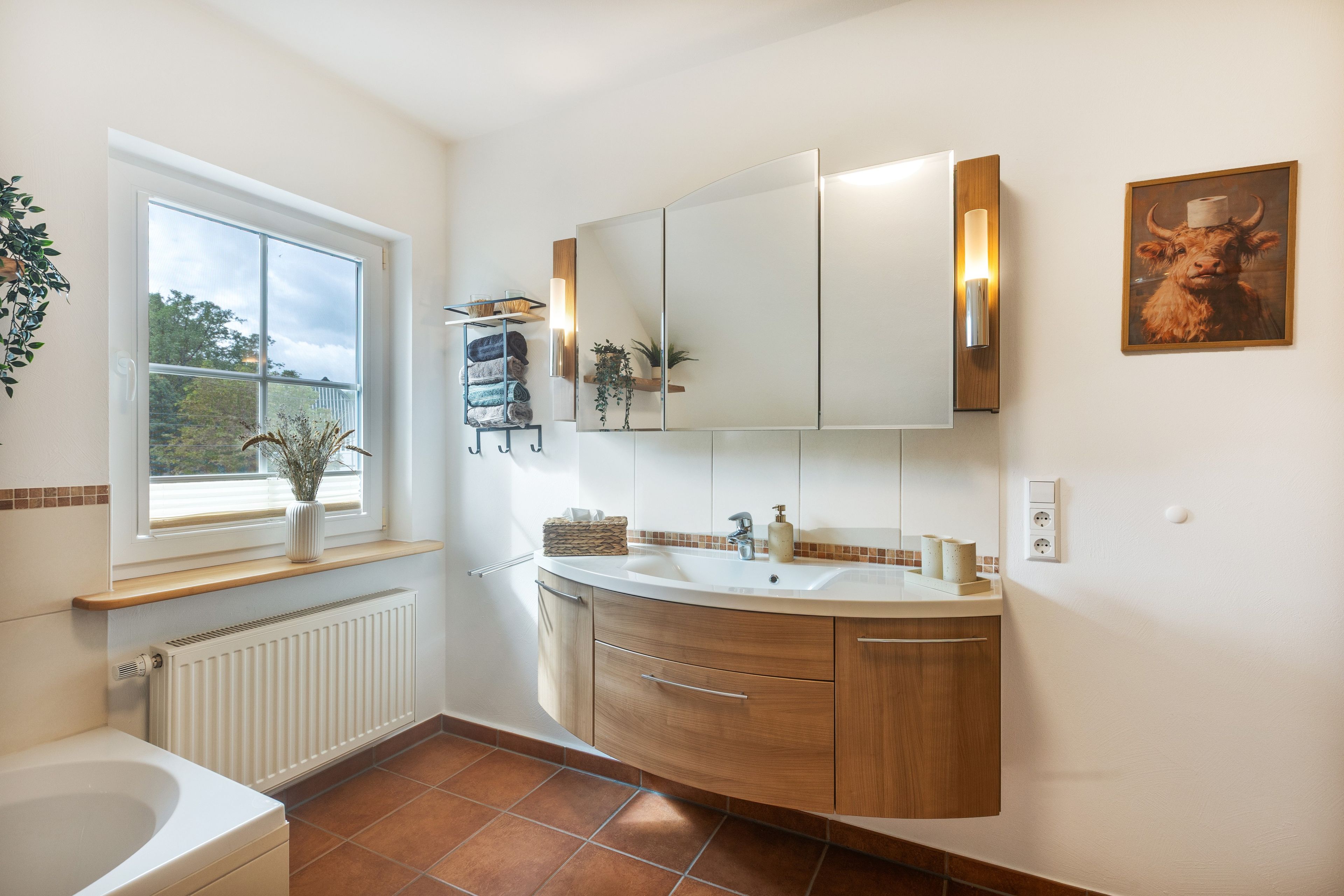 Ein Badezimmer mit einer Badewanne, einem Waschbecken und einem Spiegel.
