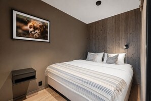 A bedroom with a bed, a nightstand, a framed picture, and a wooden headboard. - Ski-in / Ski-out apartment in Hemsedal (Hemsedal)