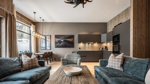 A modern living room with a wooden coffee table, two sofas, a dining area, and a kitchen with built-in appliances. - Ski-in / Ski-out apartment in Hemsedal (Hemsedal)