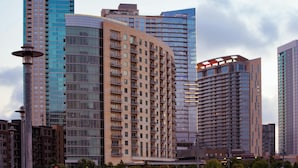 A modern high-rise building with multiple floors, large windows, and a curved facade.