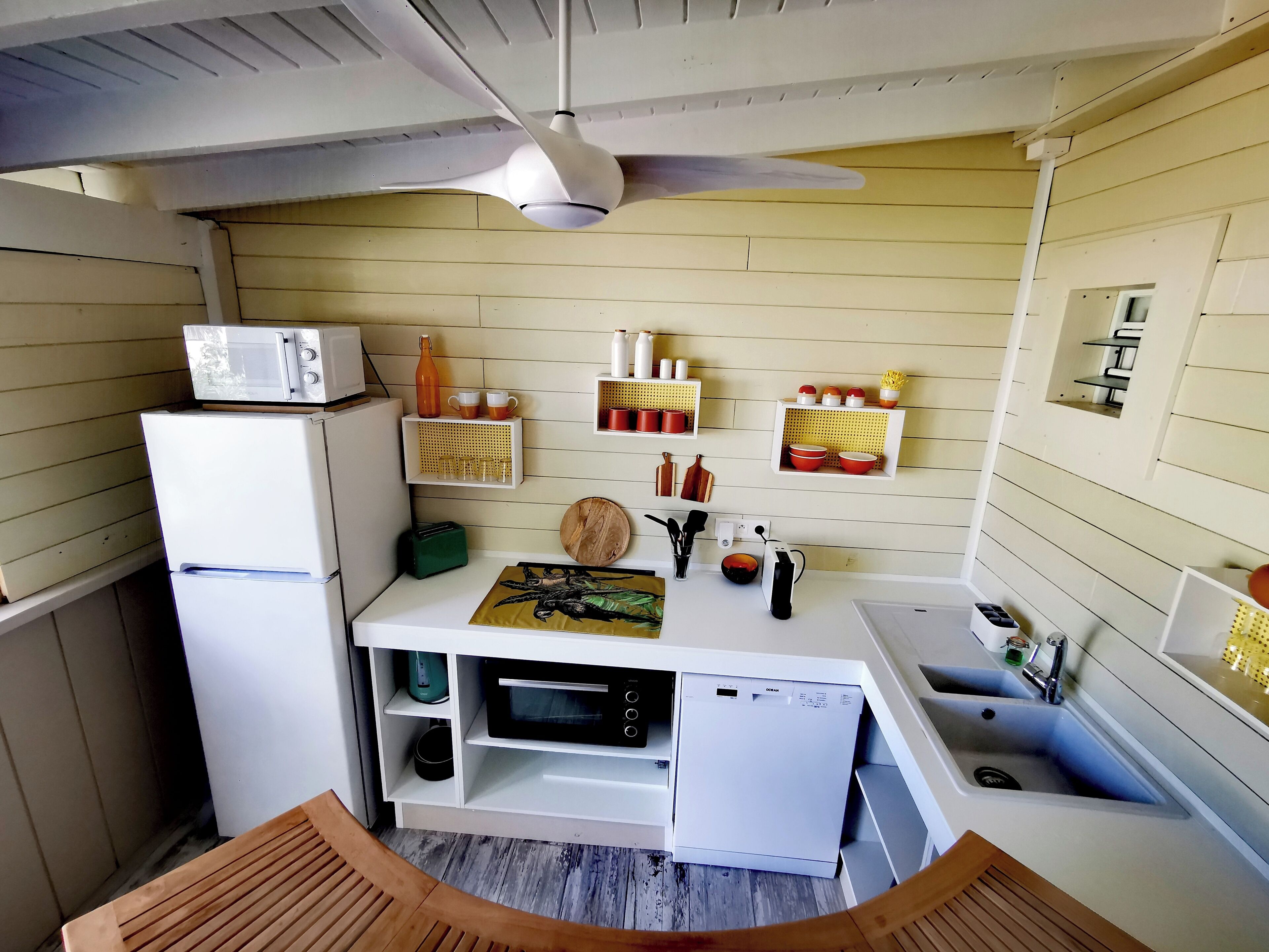 A compact kitchen with a microwave, toaster, and sink.