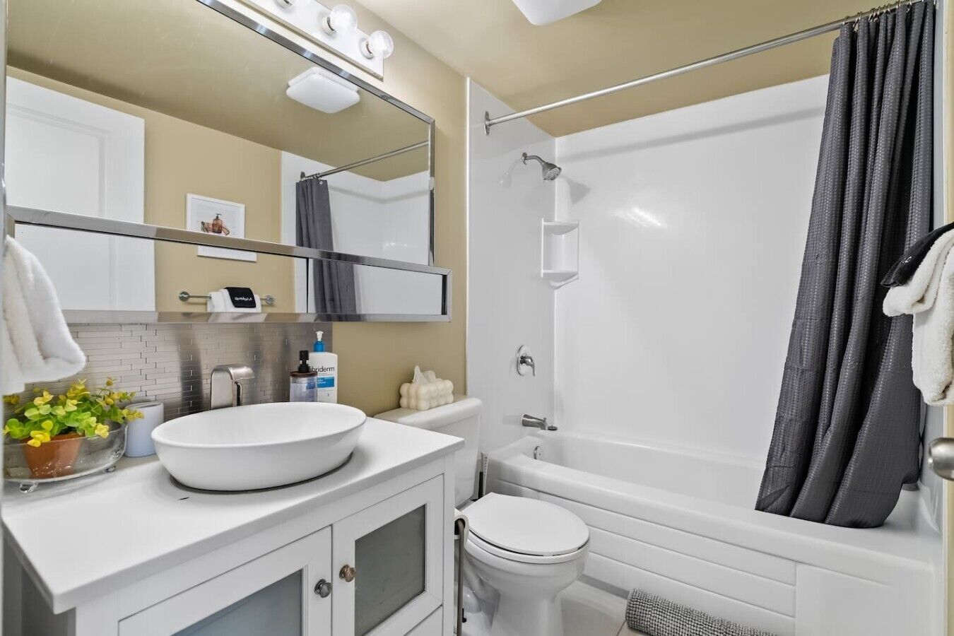 Une salle de bain avec un lavabo, des toilettes et une baignoire, le tout de couleur blanche.