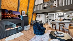 Ein modernes Interieur mit Kamin, Sitzecke, Küche und einem Balkon.