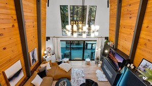Ein modernes Interieur mit Sofa, Couchtisch, Kamin und Fernseher.