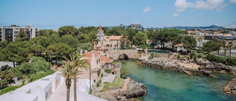 Un pueblo costero con un río, un puente e iglesia destacada con torre.