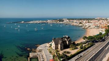 A coastal town with a marina, beach, and historic buildings.