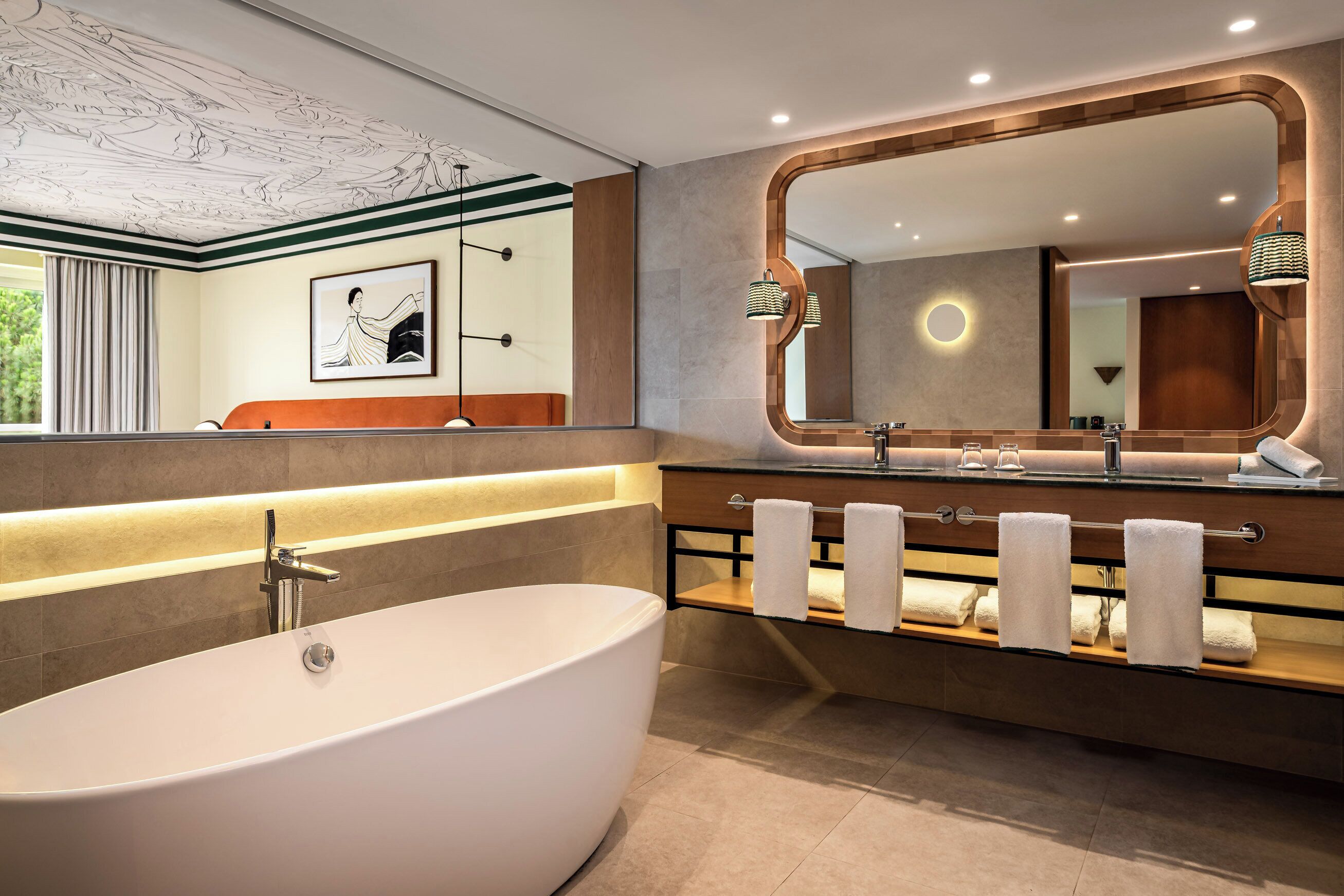 Une salle de bain moderne avec une baignoire sur pieds, un grand miroir et un porte-serviettes.