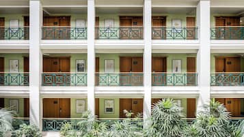 Ein mehrstöckiges Hotel mit Balkonen, Holztüren und gerahmten Kunstwerken.
